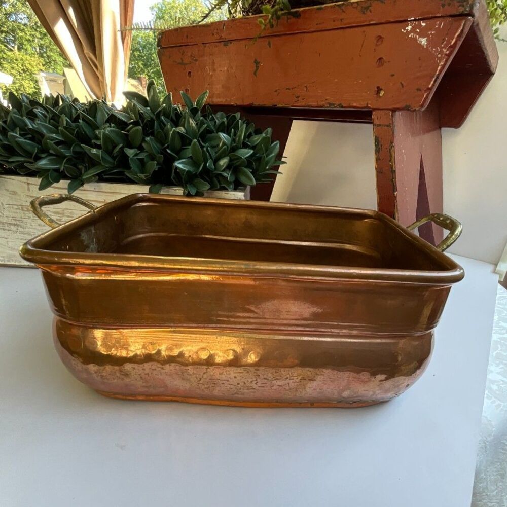 Antique hand-worked copper vessel visible dovetailed/soldered seam, hammered